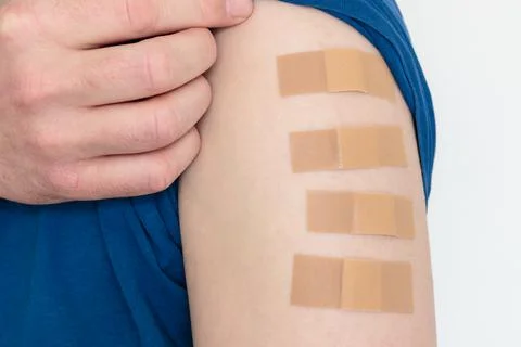 Close up of multiple bandages plasters on upper arm Stock Photos