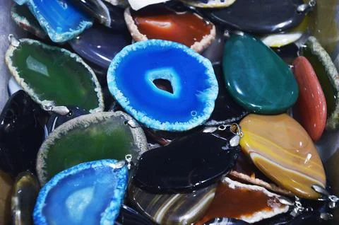 Close-up of multiple colored agate crystal slices lying haphazardly on a tabl Foto stock