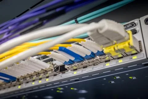 Close-up of multiple colored fiber optic LC connectors and network cables Foto stock