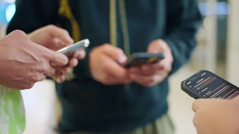 Close Up of Multiple Hands Holding Smartphones Checking Information Together. Vídeos de archivo 341988996