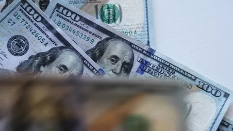 Close-up of multiple hundred-dollar bills stacked together, showcasing intricate Stock Footage 325140517