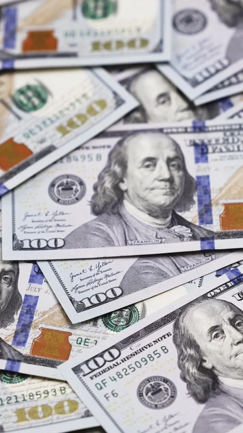 Close-up of multiple hundred dollar bills stacked together, showcasing intricate Stock Footage 328124703