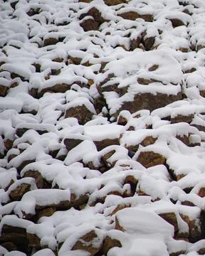 Close up of multiple layers of rocks covered with snow during winter Stock Photos
