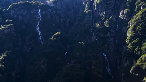 Close up of multiple mountain waterfalls in green forest Stock Footage 95824707