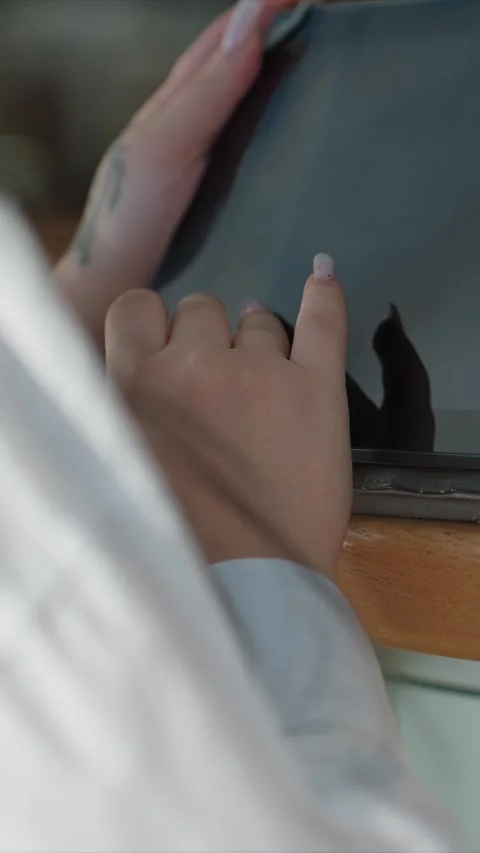 Close up of multiple people interacting continuously with tablet indoors on dark Stock Footage 344680117
