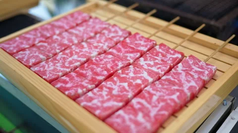 Close up of multiple pieces of Wagyu beef on a wooden tray at a street food Stock Footage 309544648