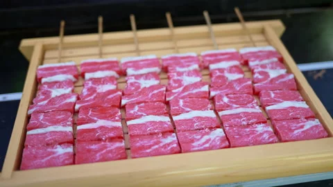 Close up of multiple pieces of Wagyu beef on a wooden tray at a street food Stock Footage 309544659