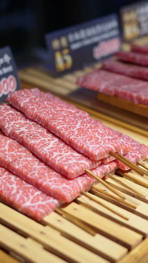 Close up of multiple pieces of Wagyu beef on a wooden tray at the Tsukiji Fish Video stock 309666568