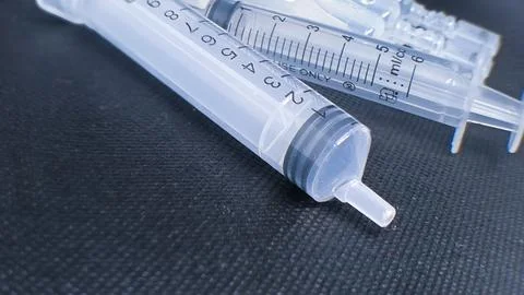 Close-Up of Multiple Plastic Syringes on a Dark Textured Surface, Highlight.. Stock Photos