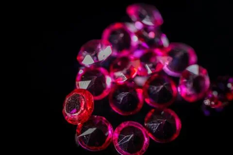 Close-up of multiple red and pink faceted gemstones scattered. Foto stock
