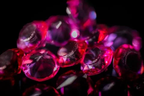 Close-up of multiple red and pink faceted gemstones scattered. Foto stock