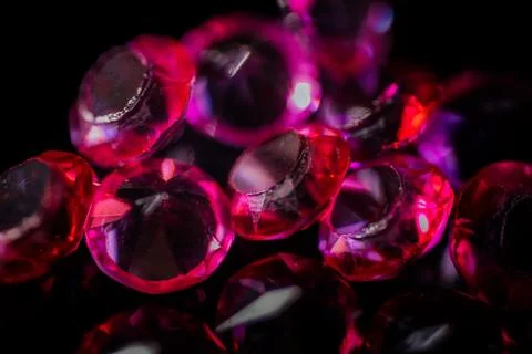 Close-up of multiple red and pink faceted gemstones scattered. Foto stock