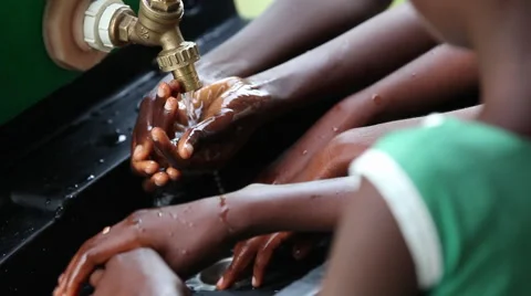 CLOSE UP:  MULTIPLE STUDENTS WASHING HANDS AT HANDWASHING STATION Stock Footage 60513528