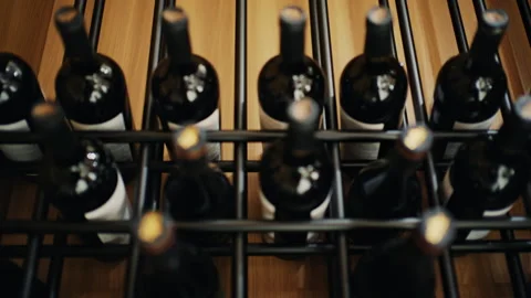 Close up of multiple wine bottles arranged in a modern rack Stock Footage 332717185