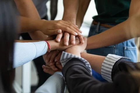 Close up multiracial business people putting hands together, showing support. Stock Photos