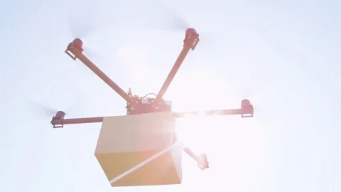 CLOSE UP Multirotor delivery drone with brown post package rising into blue sky Stock Footage 81139264