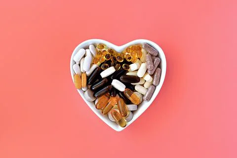 Close-up of multivitamin biologically active supplements on coral background Фото