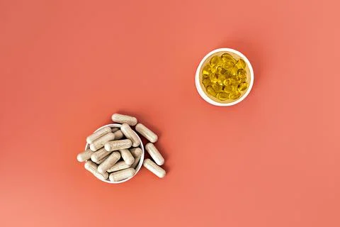 Close-up of multivitamin biologically active supplements on coral background. Foto stock