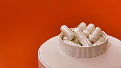 Close-up of multivitamin biologically active supplements on orange background Stock-Fotos