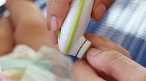 Close up of mum rasp babies nails with baby nail Trimmer Stock Footage 61777919