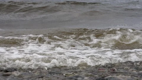 Close-up of murky brown river water with small waves breaking Stock Footage 346051598