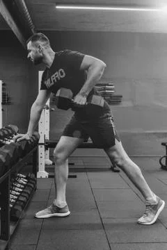 Close up of muscular bodybuilder guy doing exercises with weights in gym. Fit Stock Photos