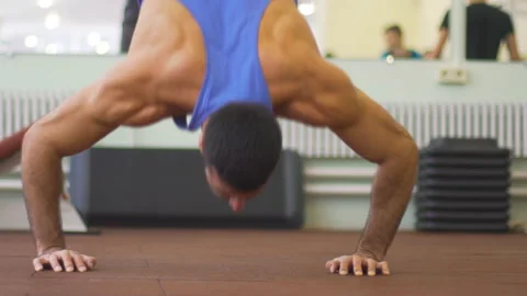 Close up to muscular man doing push ups in handstand at gym. Young athlete Stock Footage 154595064