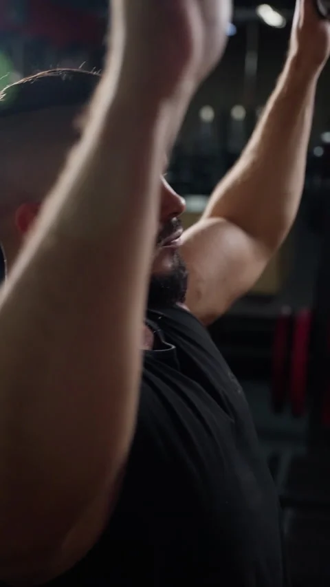 Close-up of a muscular man with a full beard and shaved head, wearing a black Stock Footage 276194455