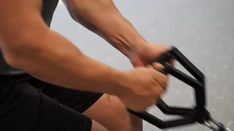 Close-up of a muscular man holding cable row handle attachment with strong .. Vidéo 344049213