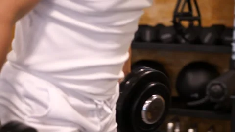 Close-up of a muscular man lifting heavy dumbbells during bench press exerc.. Video stock 344049092