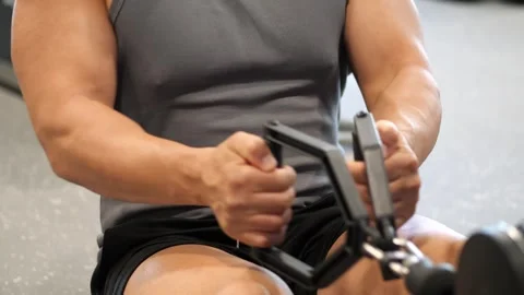 Close-up of a muscular man performing seated cable row exercise with parall.. Vidéo 344049095