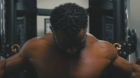 Close up of a muscular man using the cable crossover machine at the gym to build Stock Footage 89577364