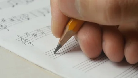 Close up of music writing. Musician composing with a pencil: staff, key, note Stock Footage