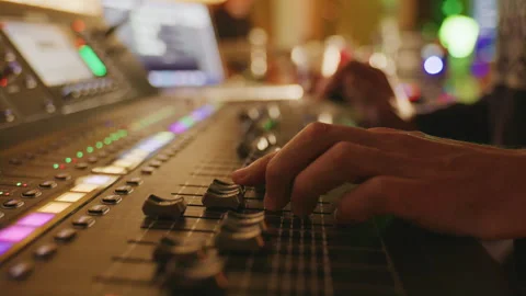 Close Up of Musician adjusting knobs on a audio mixer in Warmly Lit Music Studio 스톡 동영상 325979144