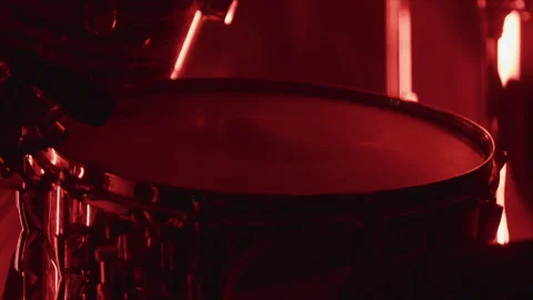 Close up of musician drumming on drum set under red lighting during live rock Stock Footage 341172671