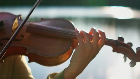 Close-up of a musicians hand gracefully playing a wooden violin outdoors near Stock Footage 340217501