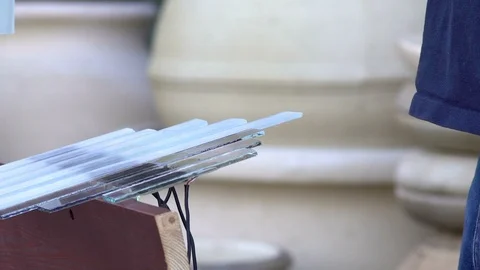 Close-up, The Musician's Hands Extract Sound from the Glass Plates of the Stock Footage 88557616