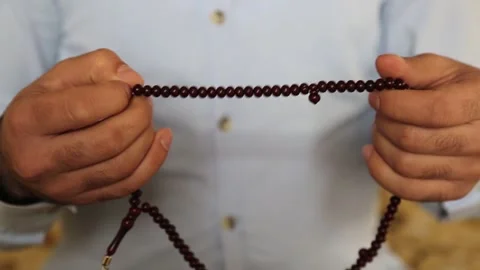 Close Up of Muslim Hand Using Prayer Beads Видео 346475427