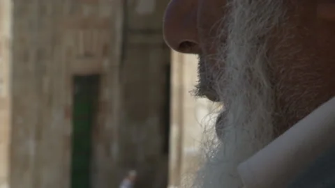 Close Up Muslim Holy Man Reading Qur'an Against The Old Stone City Of Jerusalem Stock Footage 238665554