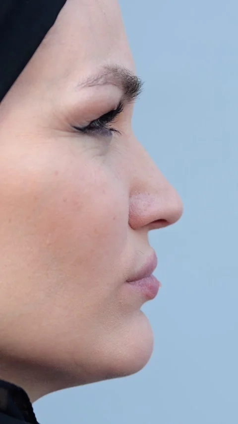 Close up of a muslim womans profile chewing and moving her jaw against a studio Stock-Footage 341442616
