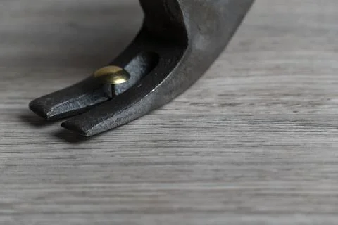 Close-Up of Nail Puller Gripping Nail on Wooden Plank Stock Photos