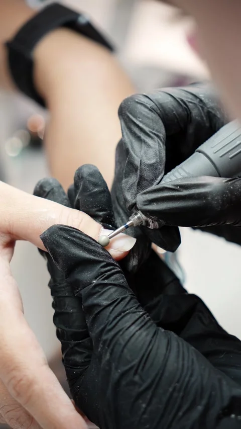 Close-up of a nail technician using a ball-shaped drill bit to remove cuticle Stock Footage 341936803