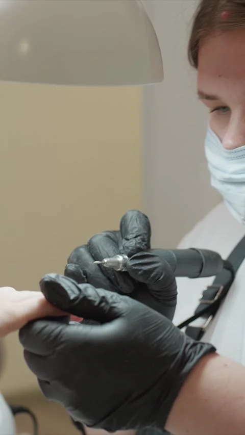 Close up of nail technician using electric file on another person fingernail in Stock Footage 348117218