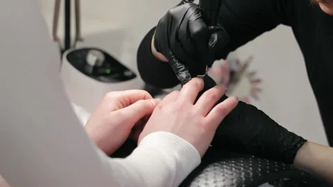 Close-up of nail technician working on client's nails. Nail technician with Stock Footage 276895064