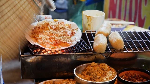 Close up of native cook preparing street food on fire grill on side of street Stock Footage 147369955