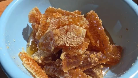 Close up of natural honeycomb frame with fresh golden liquid honey dripping from Video stock 342921924