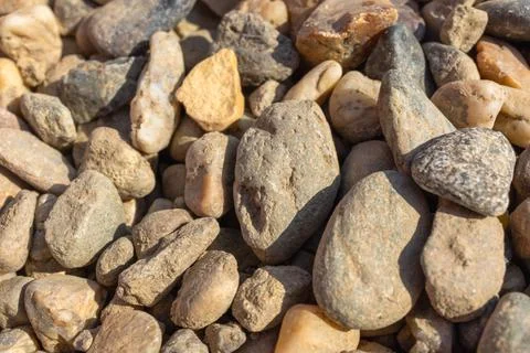 Close-up of natural river pebbles and stones in various sizes, textures, and Stock Photos