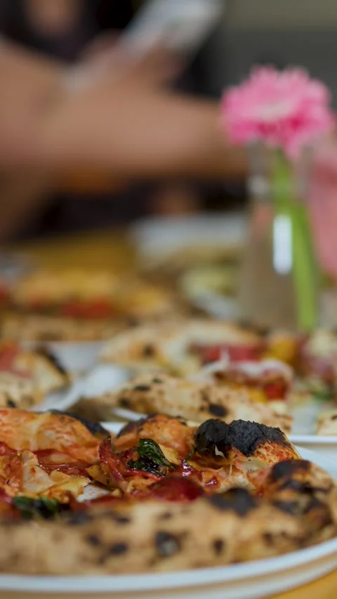Close Up of Neapolitan Pizza on Restaurant Table with People Sharing Food Stock Footage 340135044