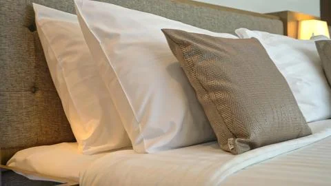 Close-up of neatly made bed with pillows in a cozy bedroom Stock Photos