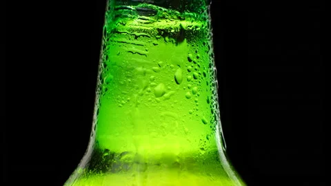 Close up Neck of a beer bottle. Cold lager beer on a black background Stock Footage 155686150